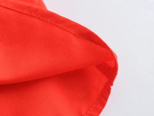 Close-up of precise stitching and red textile texture on a sweet holiday style dress