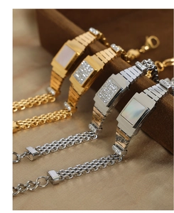 Gros plan de bracelets style montre vintage avec cristaux et nacre sur écrin brun