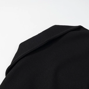 Close-up of neckline and shoulder stitching on a slim black wool coat for women