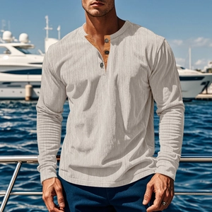 Nahaufnahme eines beigen Henley-Shirts mit Rippenstrick und drei braunen Knöpfen