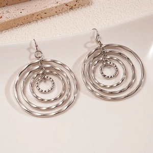 Close-up of silver hollow concentric geometric hoop earrings with hammered metal texture
