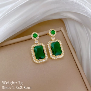 Detail of emerald green teardrop earrings in gold plating with white cubic zirconia