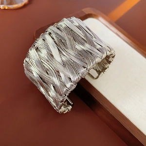 Detailed close-up of vintage multi-layer braided silver cuff bracelet with intricate textures