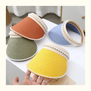Detailed straw weave textures of sun visors with elegant double-row pearl embellishments
