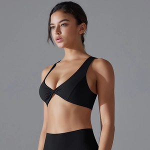 Detail of black sports bra featuring a central twist design and wide support straps