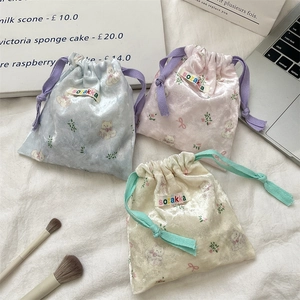 Detailed view of drawstring velvet pouches with cute cat prints and soft texture