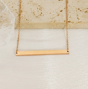 Vue détaillée du pendentif barre horizontale minimaliste plaqué or 18 carats en acier