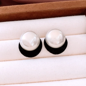 Macro view of white mabe pearl earrings with cold white luster on black base