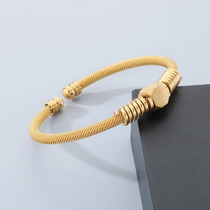 Detailed close-up of gold stainless steel cable bracelet with hexagonal geometric element