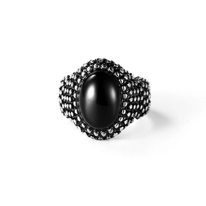 Close-up of vintage stainless steel ring with oval black gemstone and beaded texture
