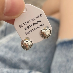 Detailed close-up of S925 sterling silver heart stud earrings with beaded edge detailing