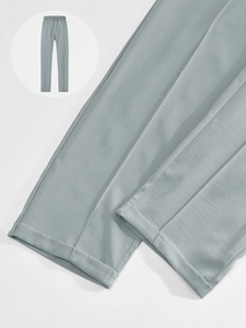 Gros plan du pantalon bleu-gris avec revers aux chevilles et plis centraux marqués