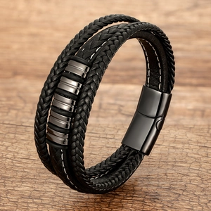 Close-up of multilayer braided leather bracelet with black magnetic clasp on wood