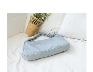 Detail of light blue nylon shoulder bag with ruffled strap and soft ruched texture