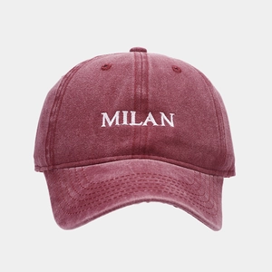Detail view of burgundy washed cotton baseball cap with white MILAN embroidery and stitching