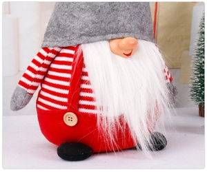 Detail of Christmas gnome plush with gray felt hat and red white striped knit fabric