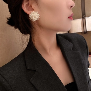 Close-up of cluster pearl flower stud earrings in cream white on a female model