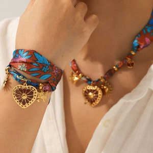 Détail de l'ensemble collier et bracelet en soie avec pendentifs papillon dorés