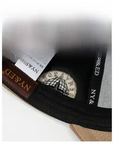Close-up of the internal stitching and 100% cotton label of a bicolor baseball cap