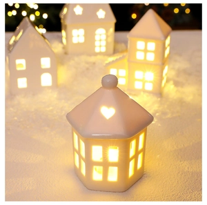 Detail of ceramic Christmas house with heart and star cutouts and warm glowing light