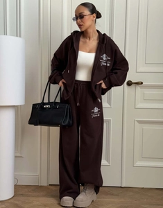 Détail du survêtement marron foncé avec broderie blanche et coupe décontractée femme