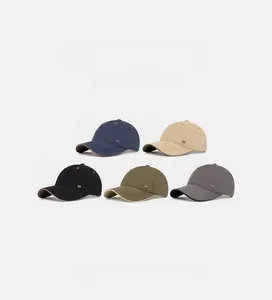 Detail of five assorted baseball caps in navy, beige, black, green, and gray colors