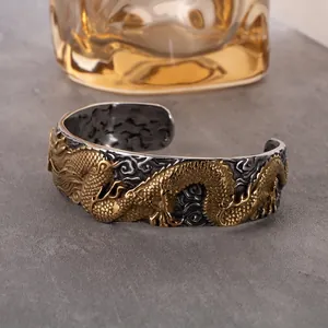 Vintage stainless steel cuff bracelet featuring embossed golden dragon and cloud patterns