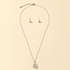 Close-up of silver teardrop pendant and matching stud earrings jewelry set with zircon