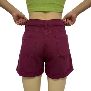 Dettaglio di pantaloncini di denim viola a vita alta con bordi sfrangiati e tasche