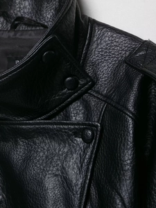 Detailed close-up of stand collar, epaulettes and buttons on black faux leather jacket