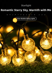 Close-up of solar bubble globe string lights with warm yellow glow for patio decor