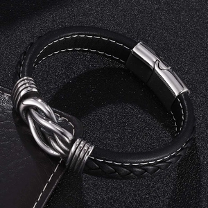 Detail of black braided leather men's bracelet with silver metal knot and magnetic clasp