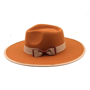 Orange cashmere wide brim fedora hat with beige ribbon and feather accessory