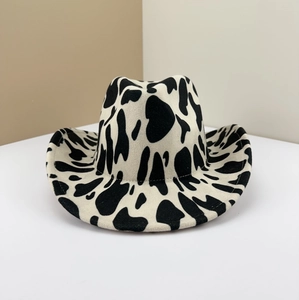 Detailed close-up view of a vintage cow print woolen felt cowboy hat on a studio background