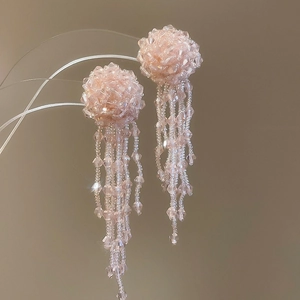 Macro shot of pink beaded jellyfish tassel earrings with high-gloss crystal details
