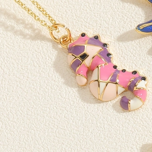 Detail of seahorse pendant with colorful enamel inlay on a gold-plated link chain