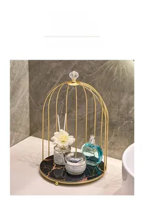 Golden birdcage-style vanity organizer with marble base for cosmetics and perfumes