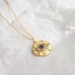 Macro detail of gold-plated Evil Eye pendant necklace with blue zircon and white crystals