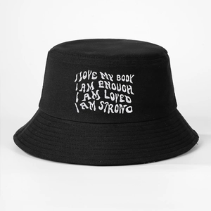 Detail of white embroidery on a black cotton bucket hat with positive motivational text
