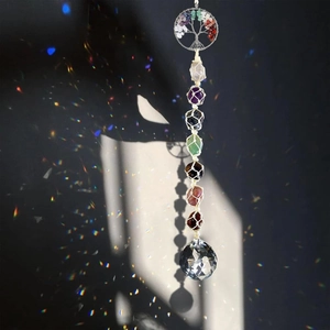 Close-up of a handmade 7 chakra tree of life suncatcher with multi-colored healing crystals
