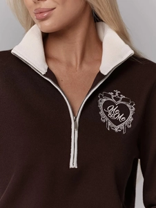 Dettaglio del ricamo a cuore con testo Me & Me sul maglione lavorato a maglia marrone