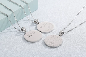 Macro detail of three silver stainless steel round pendants with engraved inspirational words