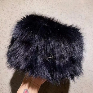 Detailed close-up of soft navy blue faux fur texture with a small metal ring attachment