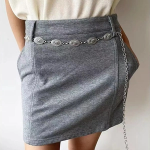Retro ethnic engraved silver metal waist chain belt on a slim grey knit mini skirt