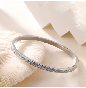 Close-up of silver titanium steel bracelet with double-row pavé crystals on coral base