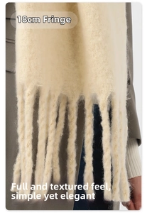Detail shot of fluffy cream knit scarf showing 18cm long fringes and soft wool texture