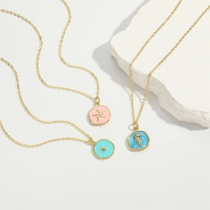 Three dainty gold enamel necklaces featuring star, seahorse and sunburst pendants