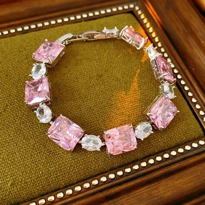 Detail of silver bracelet featuring pink and white rectangular zircon stones in wood box