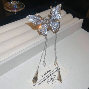 Detail of silver butterfly hair claw clip with sparkling zircon wings and long tassels