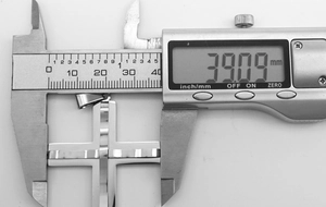 Technical close-up showing the 39.09mm width measurement of the silver cross pendant